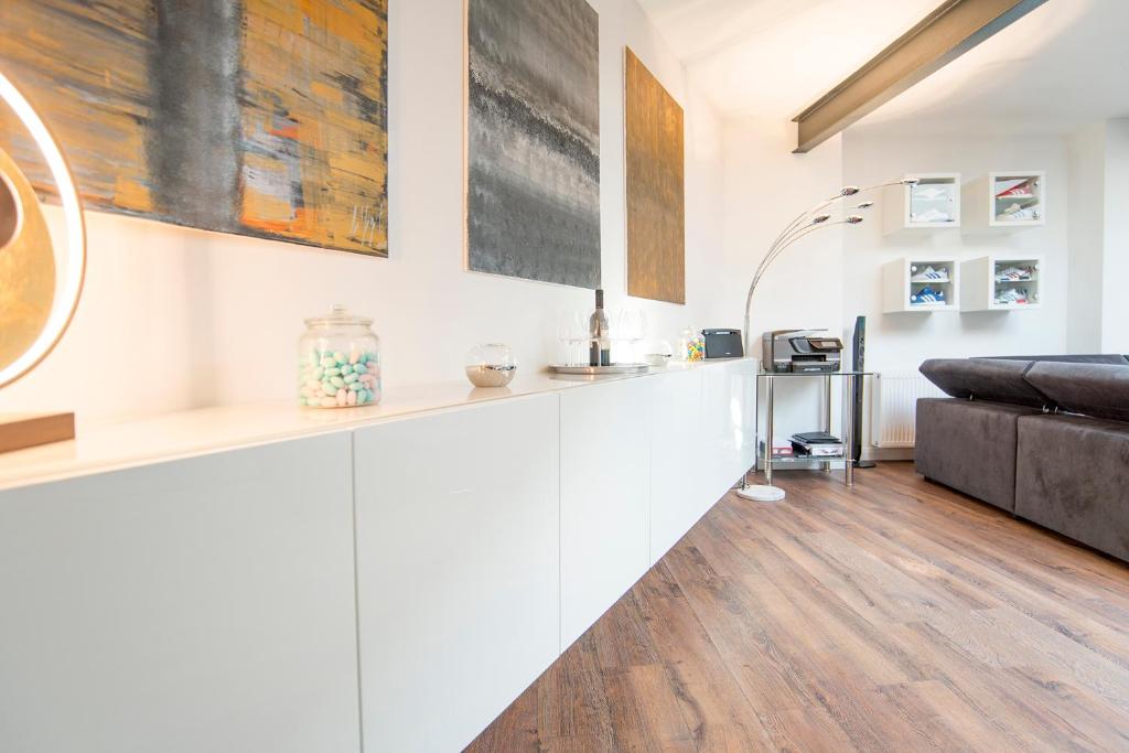 ein Wohnzimmer mit weißen Wänden und einem Sofa in der Unterkunft White Lofty und White Studio in Düsseldorf