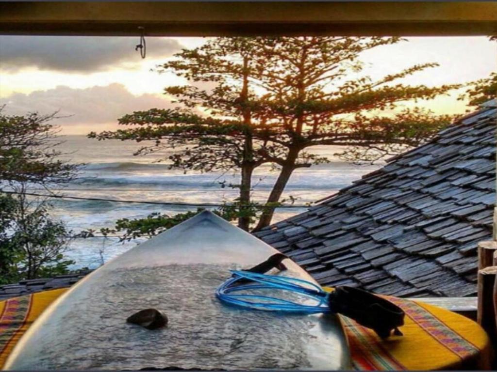 a kayak sitting on the beach with the ocean at Pousada Hanalei in Itacaré