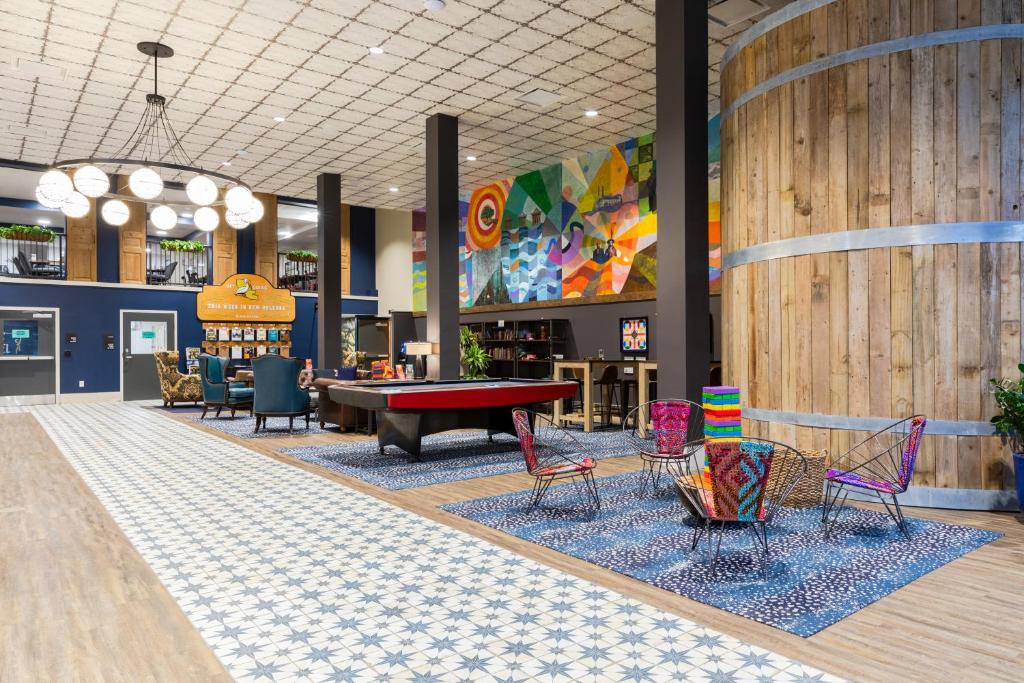 een lobby met kleurrijke stoelen en een pooltafel bij HI New Orleans Hostel in New Orleans