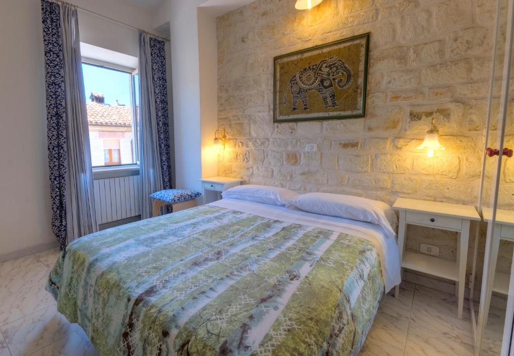 a bedroom with a bed and a stone wall at Camere Da Aldo in centro Sirolo in Sirolo