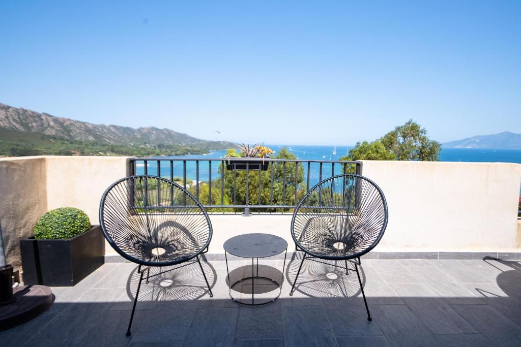 2 chaises et une table sur un balcon dans l'établissement La Citadelle Appartements, à Saint-Florent