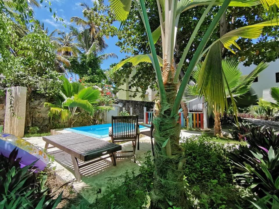 a wooden table and bench next to a palm tree at Riviera Punta Cana Eco Travelers in Punta Cana