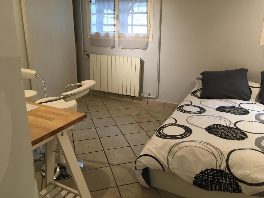 Habitación pequeña con cama y escritorio. en Appart, maison 100m2,, Parc des expositions et Aéro CDG 10mn, Parc Astérix 25mn, en Villepinte