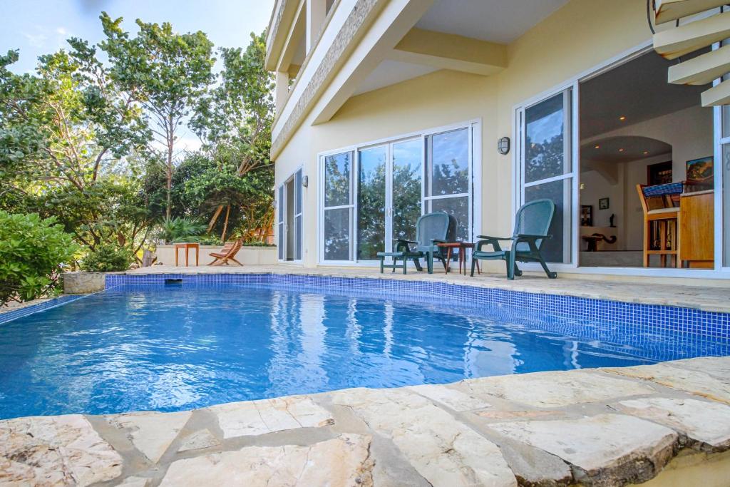 a swimming pool in the backyard of a house at Casa Chachalaca in Maya Beach