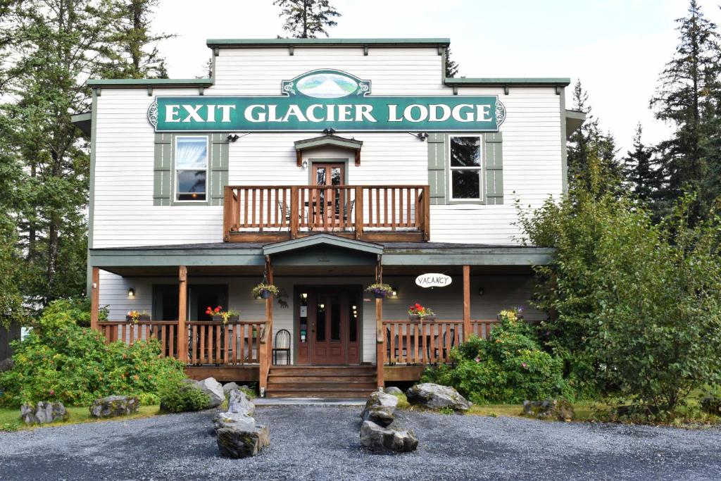 een wit huis met een uittrekbord van de gletsjer erop bij Exit Glacier Lodge in Seward