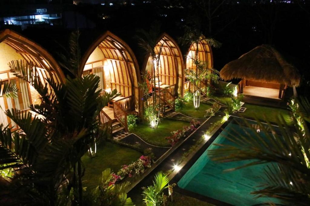 une image d'une maison avec une piscine la nuit dans l'établissement Uluwatu Sunrise, à Ungasan