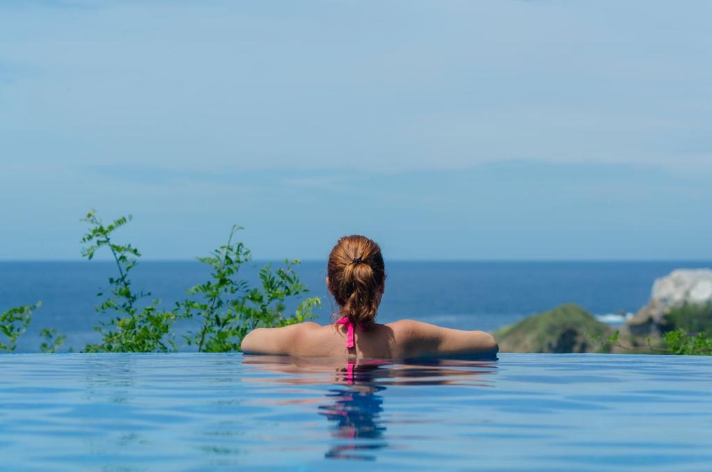 une femme assise à l'eau dans une piscine dans l'établissement Casa Biulú, à Zipolite