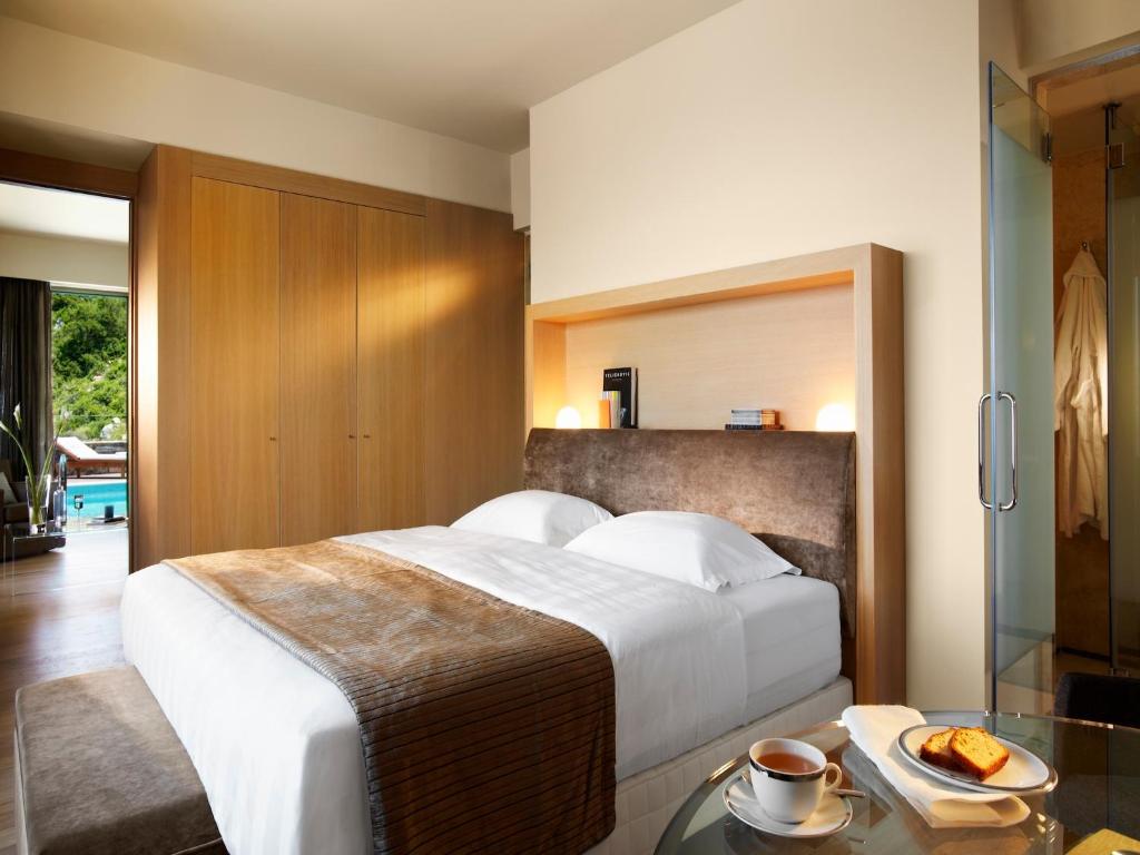 a bedroom with a large white bed and a table at Daios Cove in Agios Nikolaos