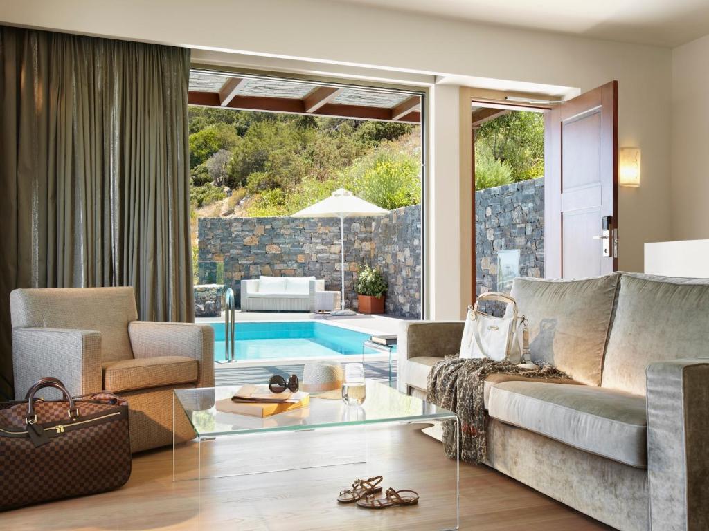 a living room with a couch and a glass table at Daios Cove in Agios Nikolaos