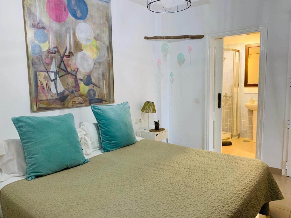 1 dormitorio con 1 cama con 2 almohadas azules en La Ballena del Charco, en Arrecife