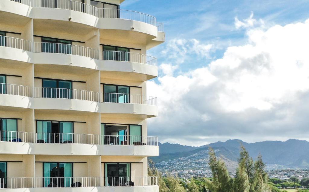 a building with balconies and mountains in the background at Lotus Honolulu at Diamond Head in Honolulu