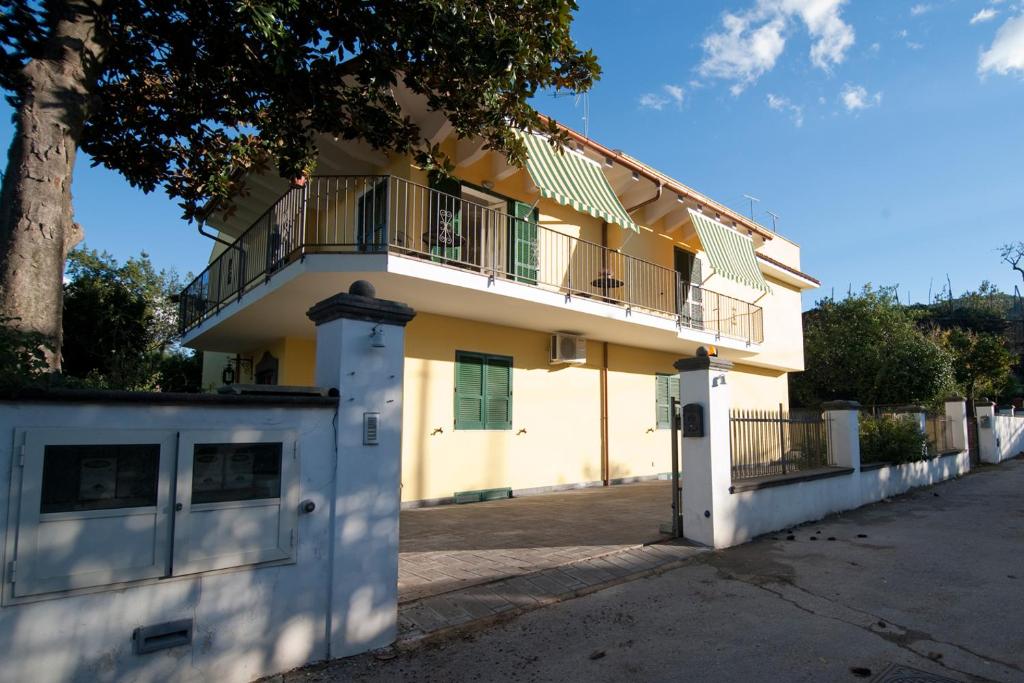 a white building with a tree and a fence at B&B Massico Apartments in Sant'Agnello