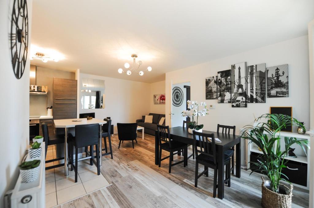 une salle à manger et un salon avec une table et des chaises dans l'établissement Disneyland Dream 1 - Charmant Appartement 4/5 pax, à Serris