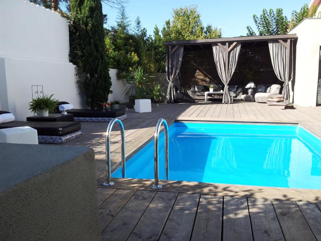 una piscina en un patio con patio y mesa en Villa Zen, en Narbona