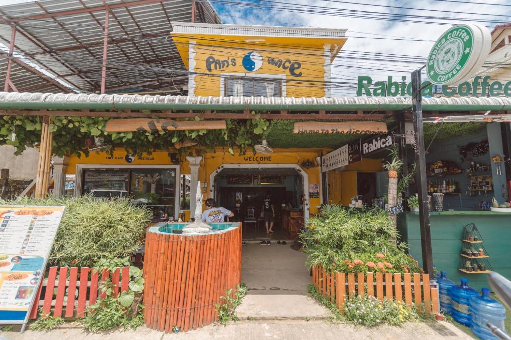un negozio di fronte a un edificio giallo con piante di fronte di Pan's Place a Vang Vieng