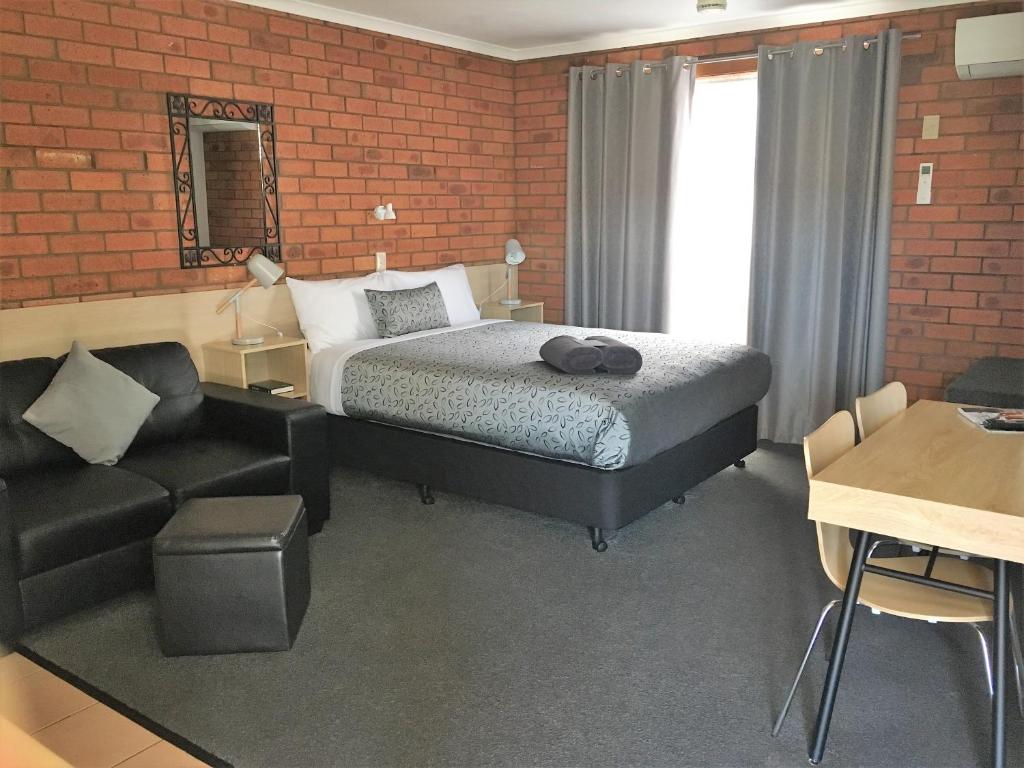 a living room filled with furniture and a bed at Shannon Motor Inn in Geelong