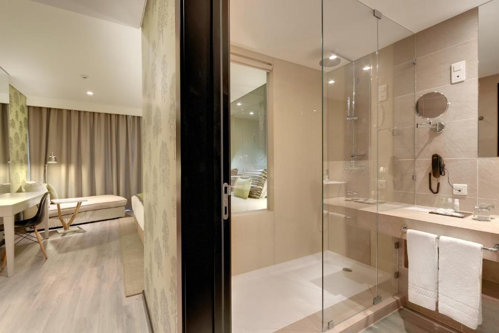a bathroom with a glass shower and a sink at Hotel Inglaterra - Charme & Boutique in Estoril