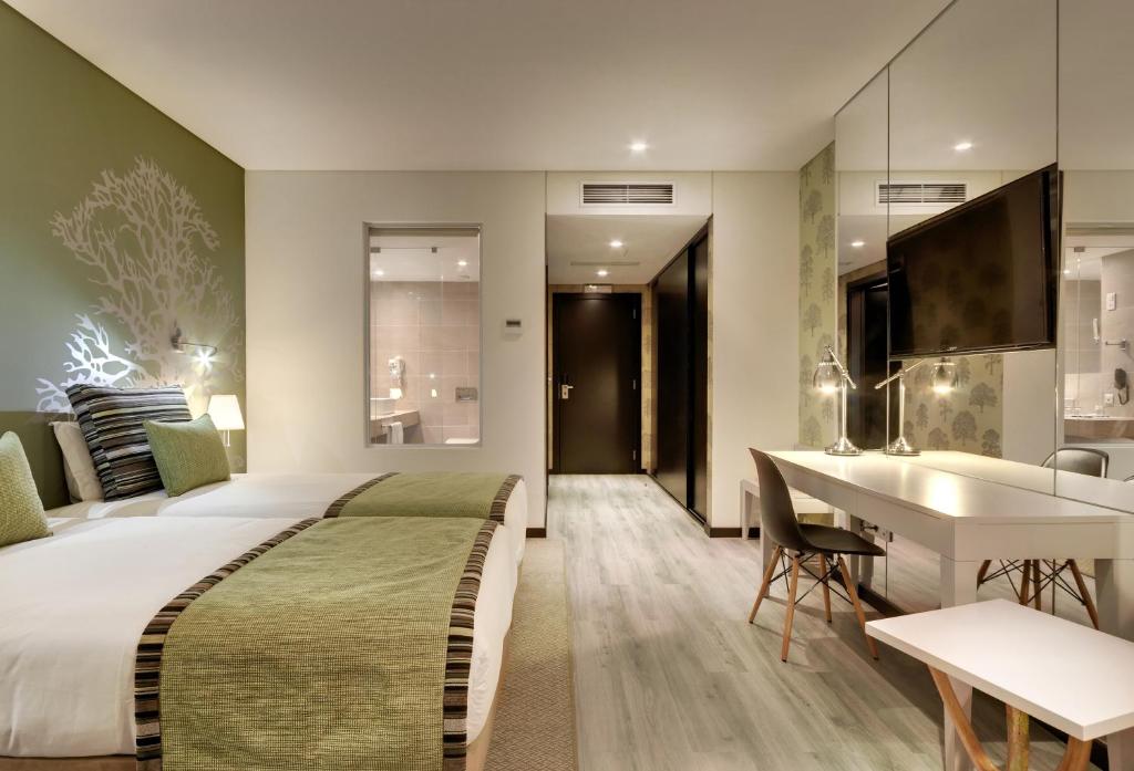 a hotel room with a bed and a desk and a kitchen at Hotel Inglaterra - Charme & Boutique in Estoril