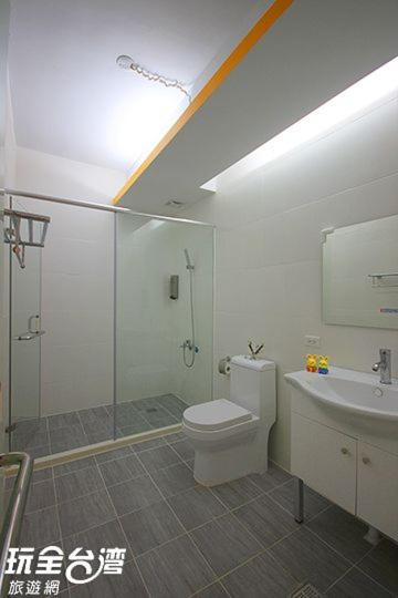 a bathroom with a shower and a toilet and a sink at Amy Walker B&amp;B in Taimali