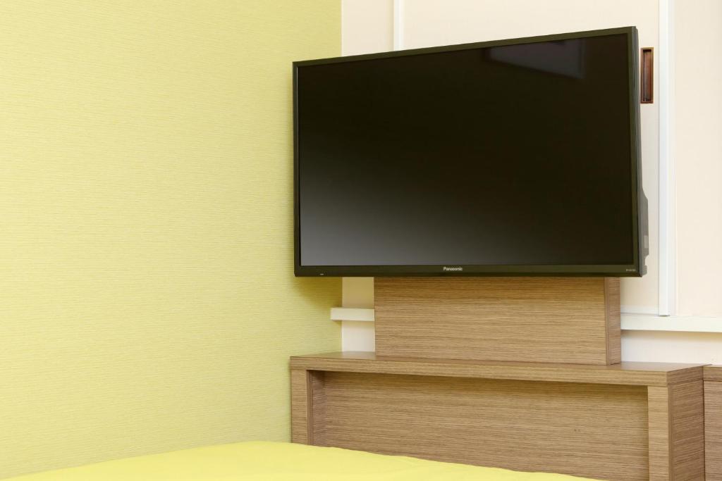 a flat screen tv sitting on a wall at Keio Presso Inn Ikebukuro in Tokyo
