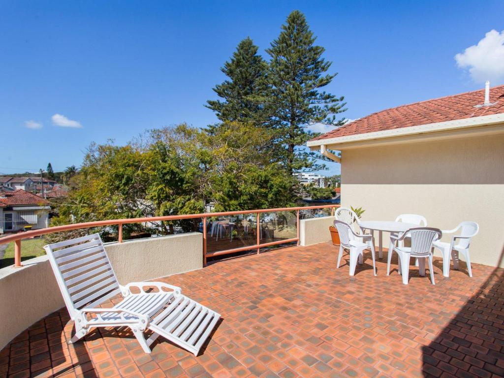 a patio with chairs and a table on a balcony at Haven Waters 6 in Forster