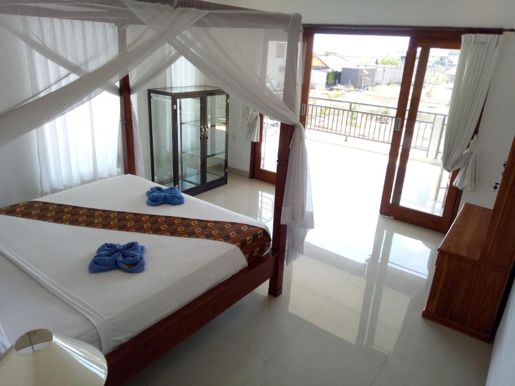 Un dormitorio con una cama con arcos azules. en Minory Guesthouse, en Amed