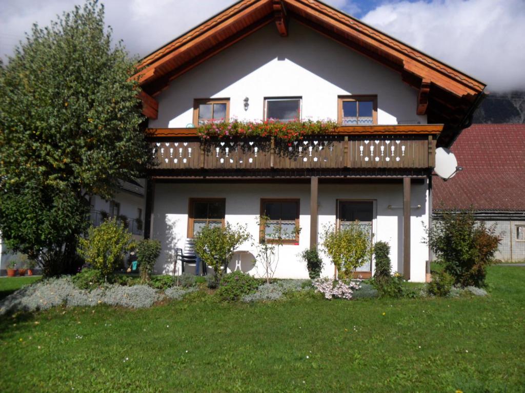 ein weißes Haus mit einem Balkon mit Blumen darauf in der Unterkunft Ferienhaus Warmuth in Sankt Stefan an der Gail