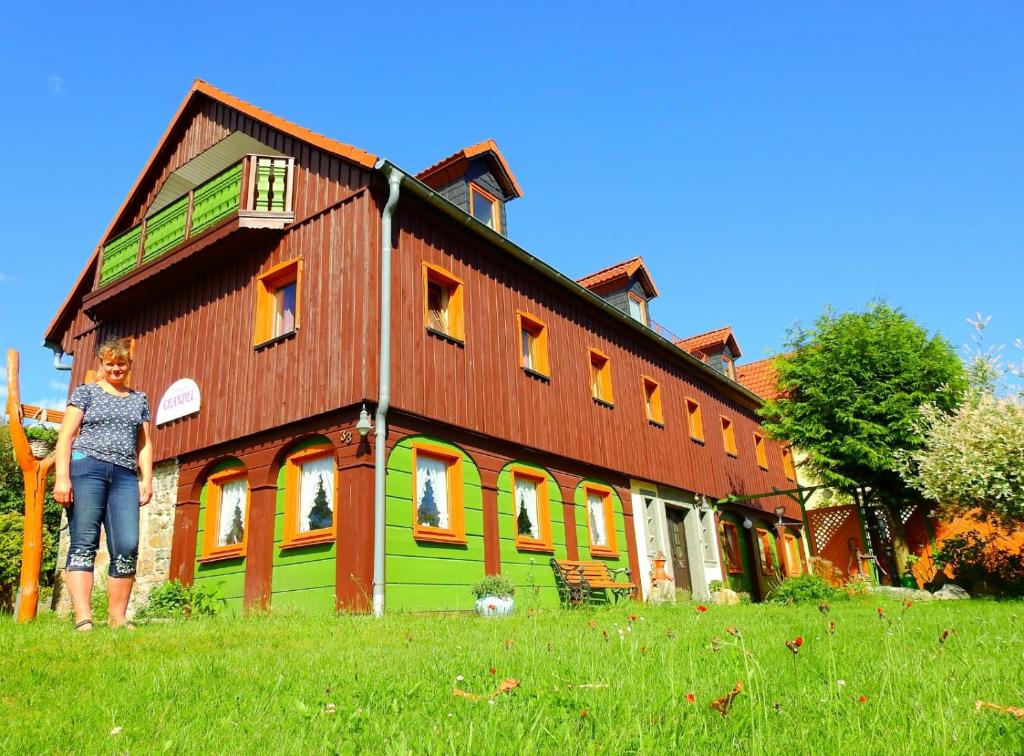 a woman standing in front of a large building at Pension Grandel in Kottmar