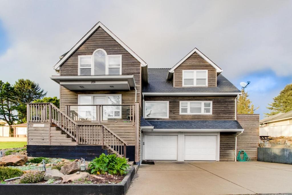 a house with a balcony and a garage at Crystal Rose Home and Cottage in Lincoln City