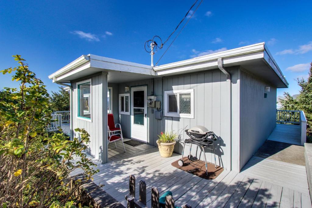 a tiny house with a patio and a grill at Whale Watch in Lincoln City
