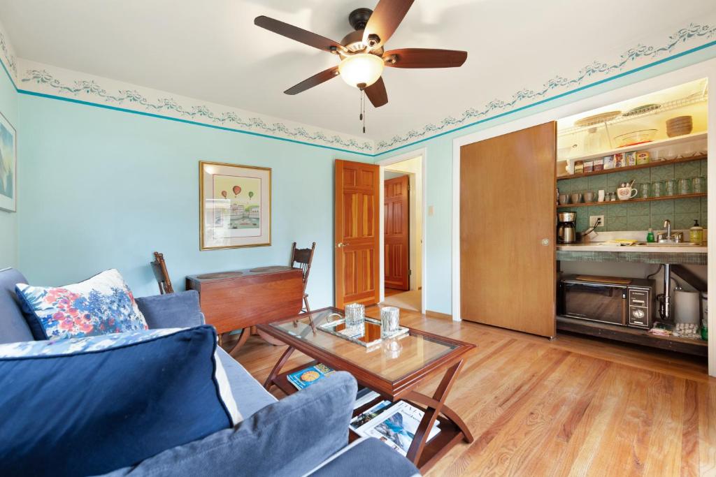 a living room with a ceiling fan and a table at Hummingbird Garden Retreat in Santa Rosa