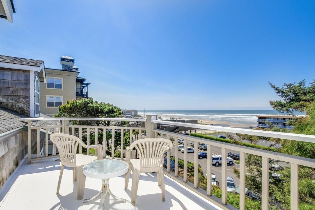 a balcony with two chairs and a table and the beach at Far View in Lincoln City