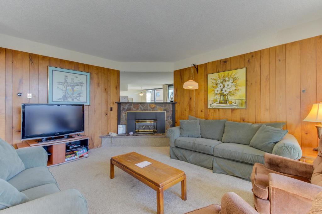 ein Wohnzimmer mit einem Sofa und einem TV in der Unterkunft Sand & Sea: The Bilberry (114) in Seaside