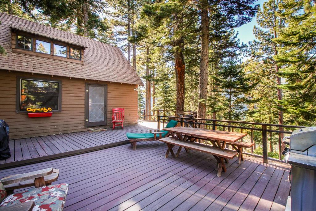 eine Holzterrasse mit einem Picknicktisch und einem Haus in der Unterkunft The Cherry Leaf Lodge & Retreat on Fallen Leaf Lake in Fallen Leaf
