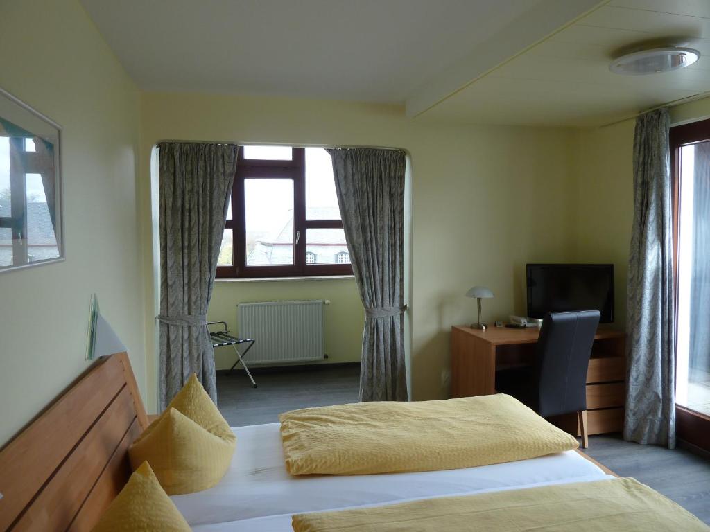 Кровать или кровати в номере Hotel am Schloss Broich