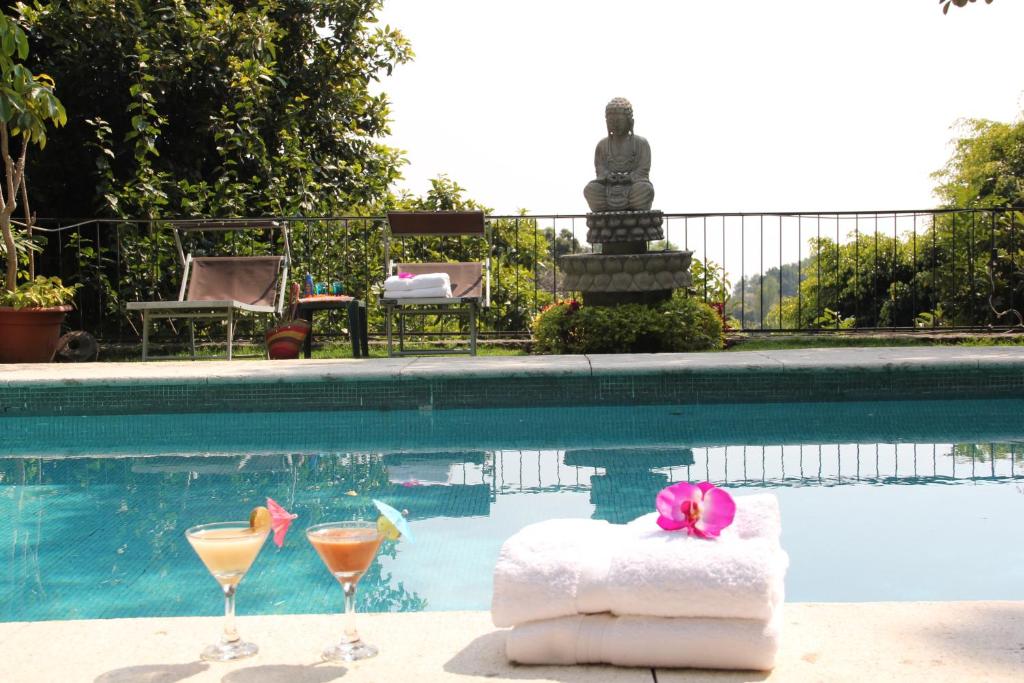 una piscina con dos vasos de martini y una toalla en Tu cabaña Cuernavaca - hospedaje by Arcadia, en Cuernavaca