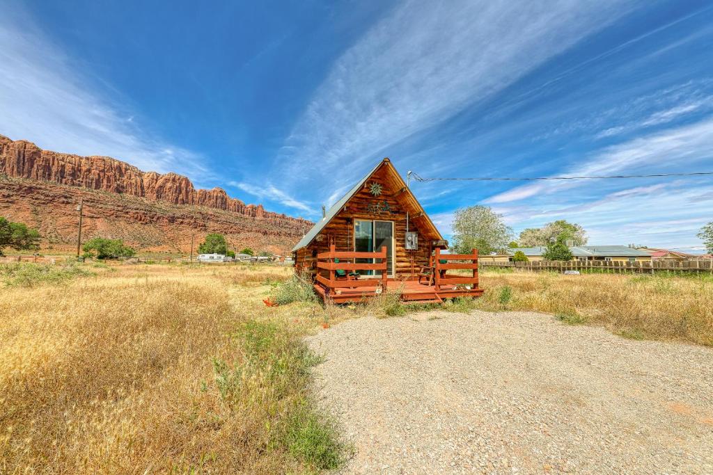 a cabin in a field with a mountain in the background at Sunny Acres Cabin in Moab