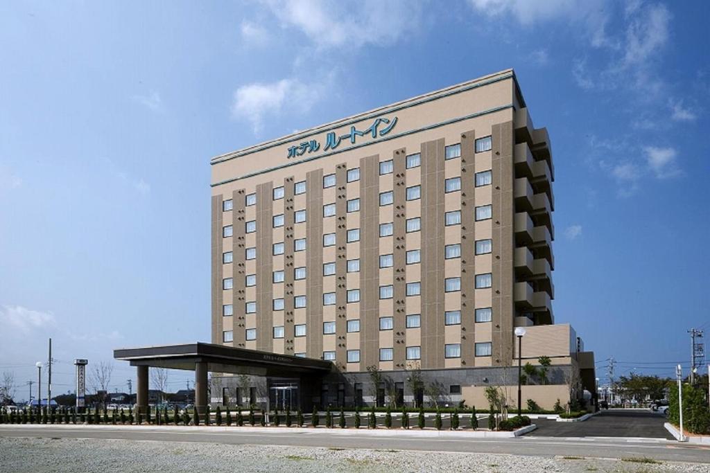 a large building with a sign on top of it at Hotel Route-Inn Mikawa Inter in Hakusan