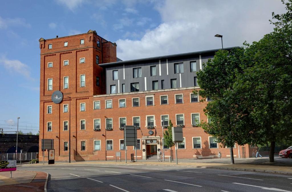 un gran edificio de ladrillo en una calle de la ciudad en The Ainscow Hotel, en Mánchester