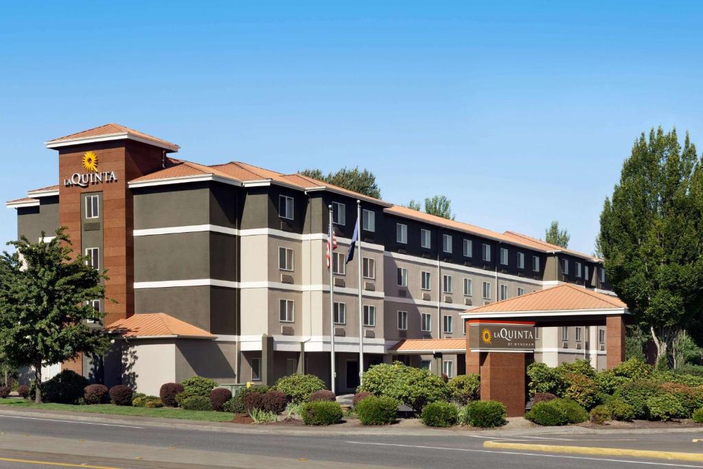 a hotel building with a clock tower on a street at La Quinta by Wyndham Salem OR in Salem