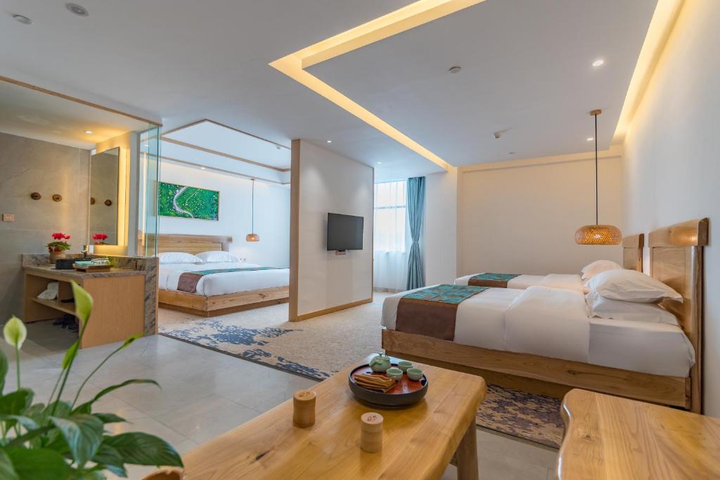 a bedroom with two beds and a living room at Yunxianju Tea Culture Theme Hotel in Kunming