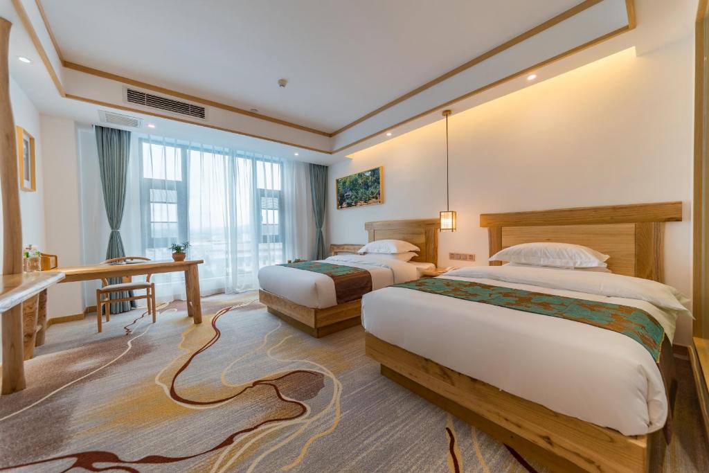a hotel room with two beds and a desk at Yunxianju Tea Culture Theme Hotel in Kunming