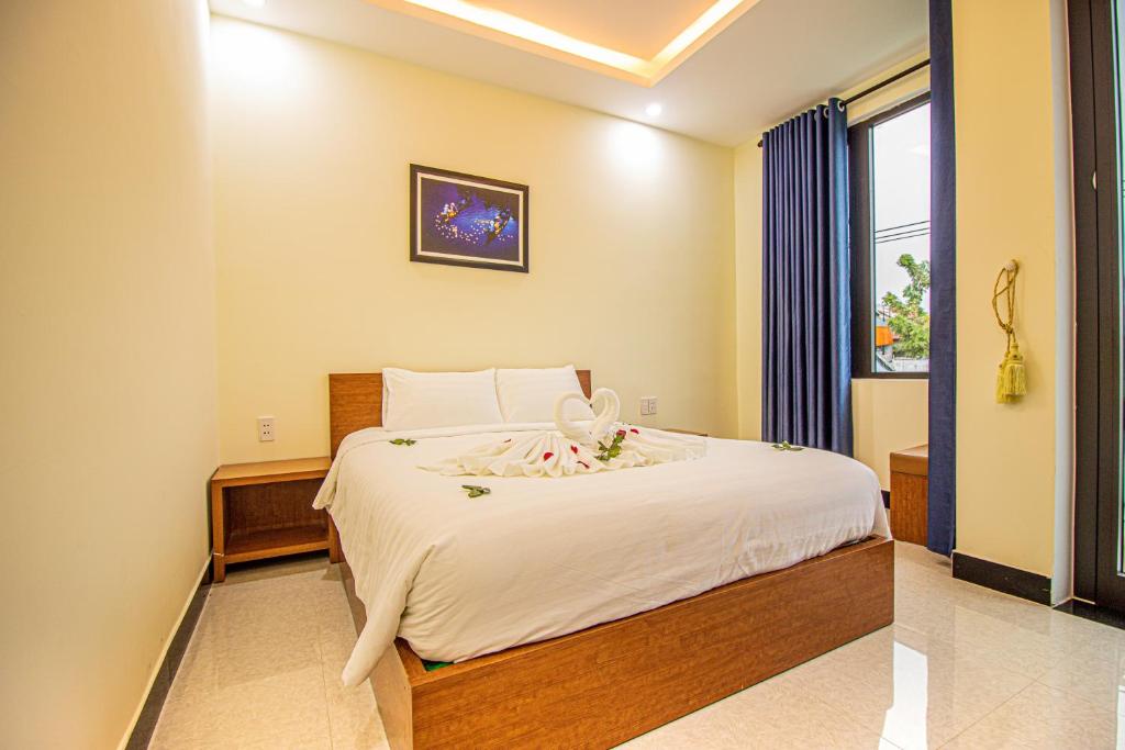 - une chambre avec un grand lit et une fenêtre dans l'établissement Gold Stone Homestay, à Hội An