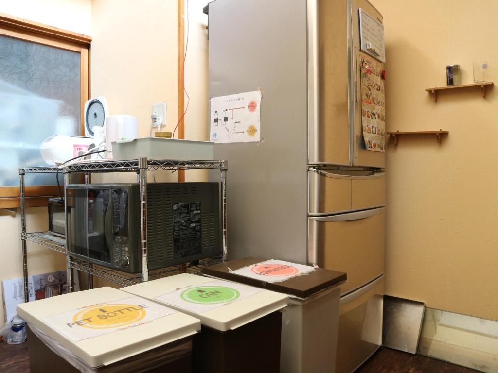 a kitchen with a refrigerator and a counter top at Guest House Minato in Miyako