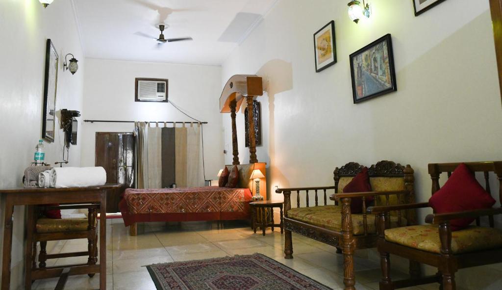 a living room with a couch and chairs and a bed at Homestay in Varanasi