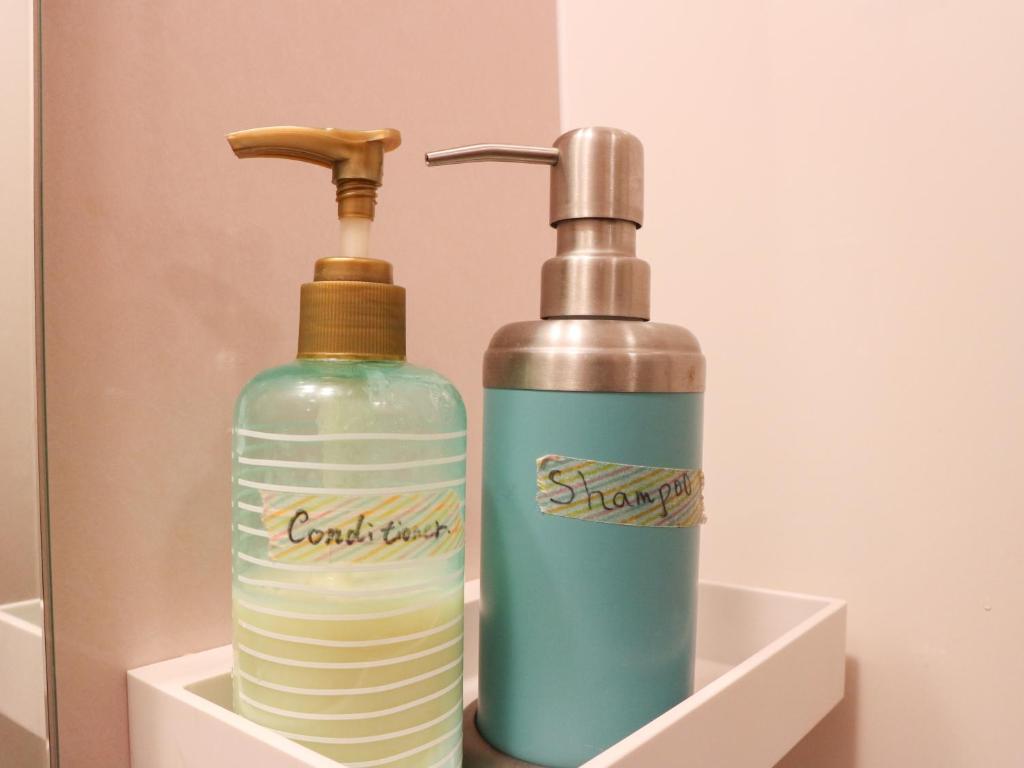 two bottles of soap sitting in a holder at Guest House Minato in Miyako