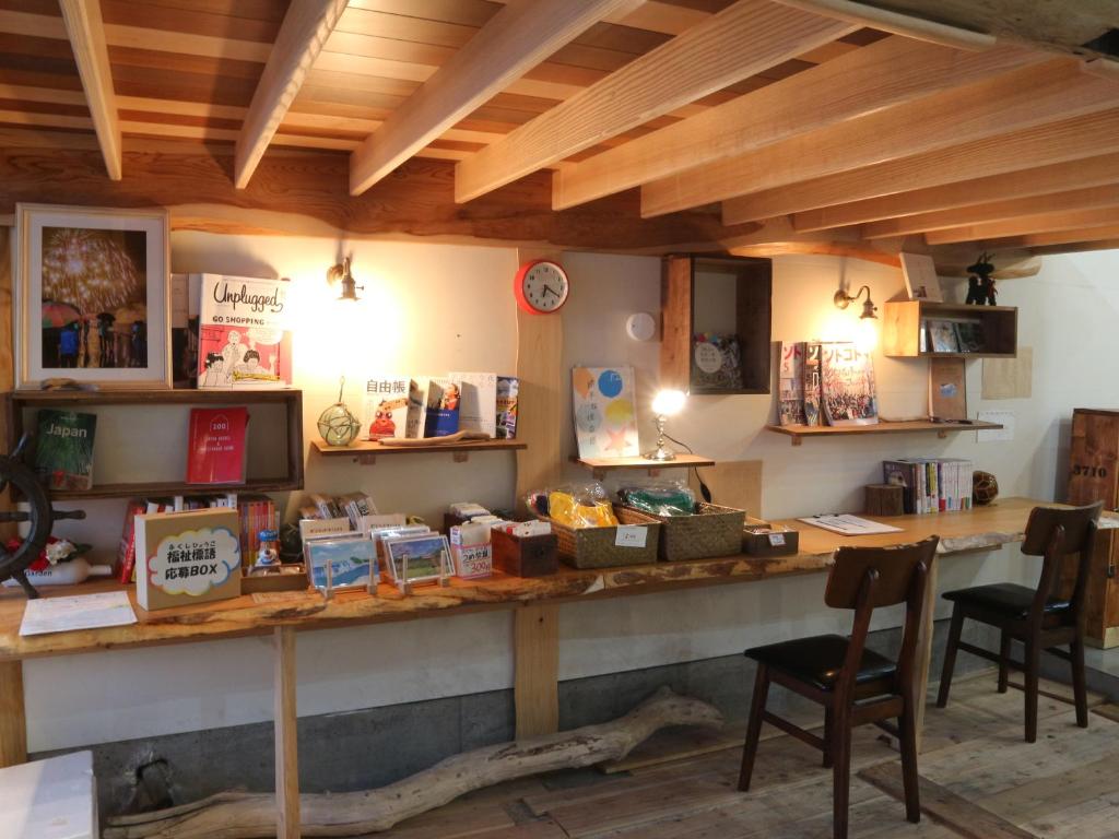 a room with a long counter with a table and chairs at Guest House Minato in Miyako