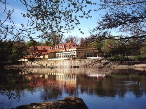 a house sitting on the side of a lake at Der Quellenhof in Helmstedt