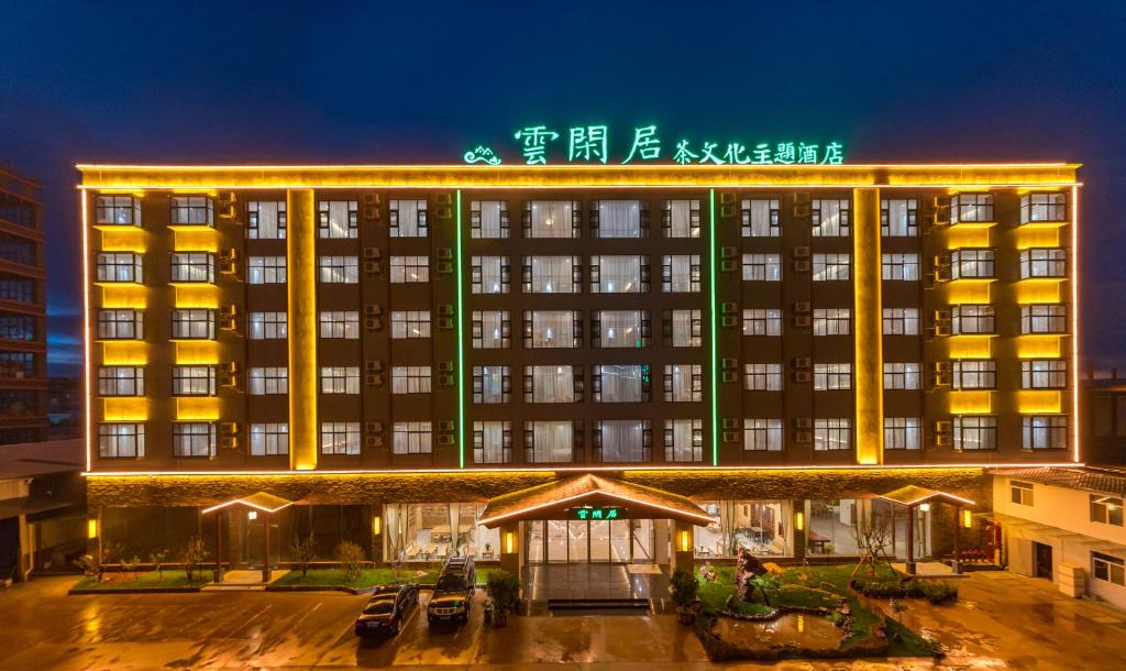 un hotel con un cartel encima de él por la noche en Yunxianju Tea Culture Theme Hotel, en Kunming