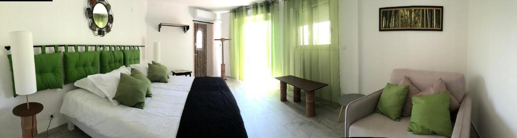 a living room with a bed with green pillows at Maxima Sunset in Sainte-Maxime